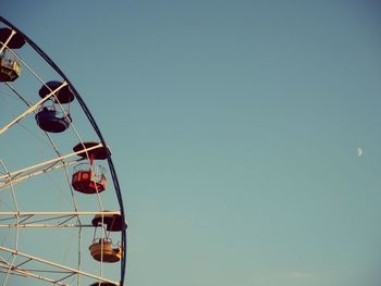 Low angle view of ferris wheel against clear blue sky