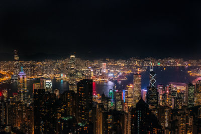 Illuminated cityscape against sky at night