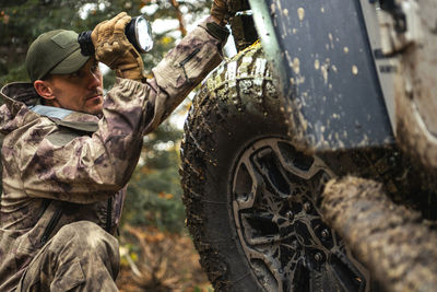 Low angle view of man standing by car