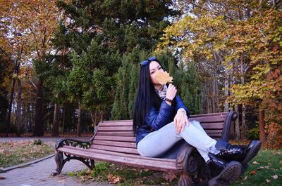 Woman sitting on bench in park