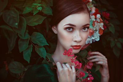 Close-up portrait of woman by flowering plants
