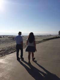 Rear view of couple walking on beach