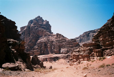 View of rocky mountains against clear blue sky