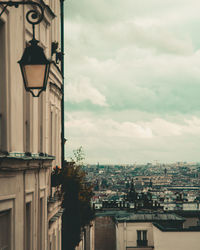 Buildings in city against cloudy sky