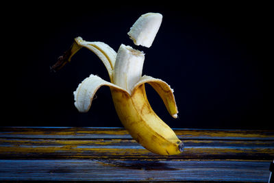 Close-up of bananas on table against black background