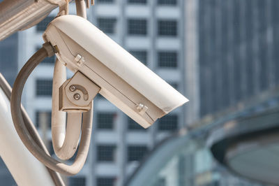 Close-up of electric lamp hanging on metal grate