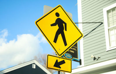 Low angle view of road sign against blue sky