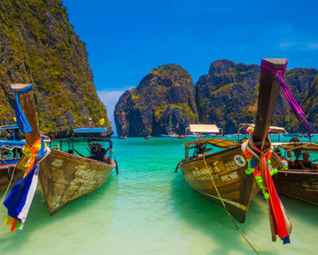 Boats moored in sea against blue sky