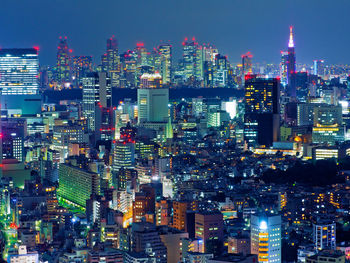 Illuminated cityscape against sky at night