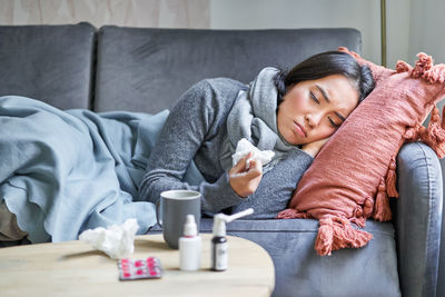 Young woman sitting on sofa at home