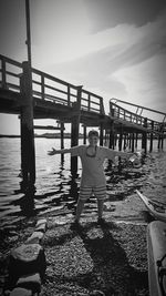 Boy standing on water against sky