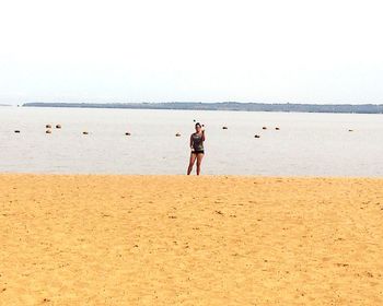 Rear view of women on beach against sky