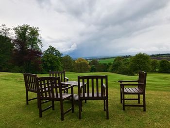 Chairs on field against sky