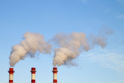 Smoke emitting from chimney against sky