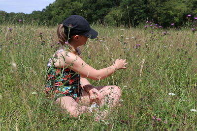 Rear view of woman sitting on field