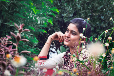 Portrait of young woman looking at plants