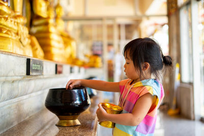 Side view of cute girl having food