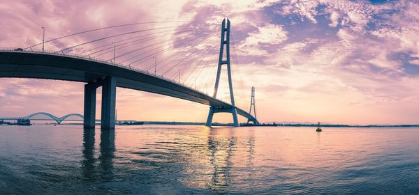 Low angle view of bridge over river against sky