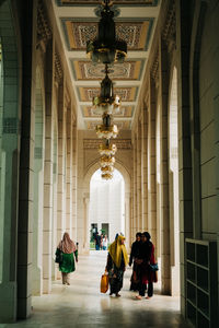 People walking in corridor of building