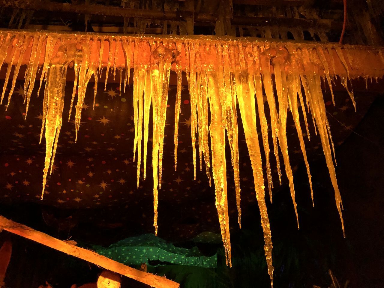 LOW ANGLE VIEW OF ICICLES HANGING FROM CAVE