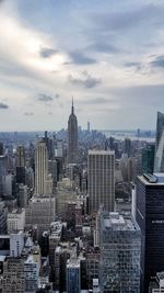 High angle view of buildings in city against cloudy sky