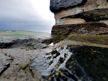 Surface level of rocks on shore against sky