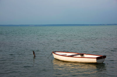 Boat moored in sea against clear sky