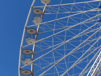 Low angle view of ferris wheel against blue sky