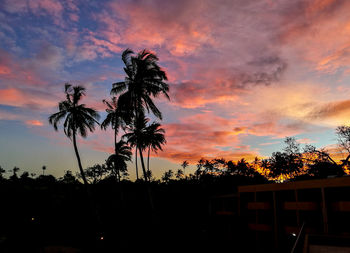 Low angle view of silhouette palm trees against romantic sky