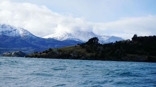 Scenic view of mountains and sea against cloudy sky