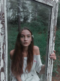 Beautiful girl with old window in the forest