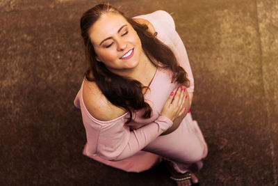 High angle view of smiling pregnant woman standing on road