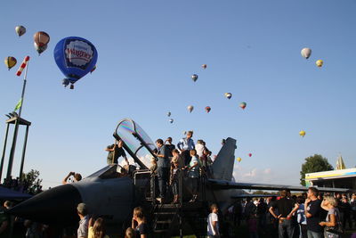 Group of people in mid-air against clear blue sky