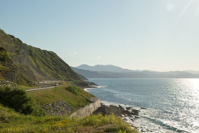 Scenic view of sea and mountains against clear sky