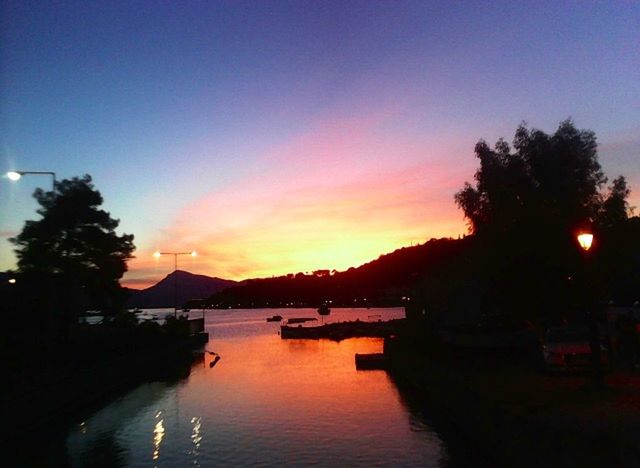 sunset, water, silhouette, sky, tranquil scene, scenics, tranquility, tree, beauty in nature, mountain, reflection, lake, dusk, nature, orange color, waterfront, idyllic, river, nautical vessel, built structure