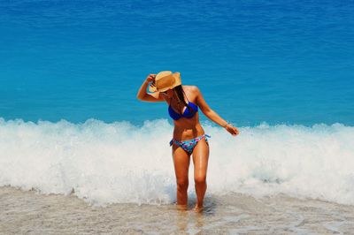 Rear view of woman jumping in sea