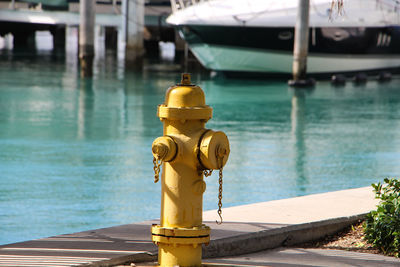 Yellow fire hydrant on promenade during sunny day