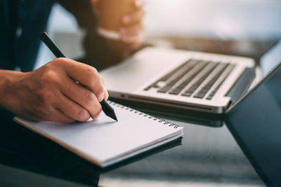 Midsection of woman using laptop on table