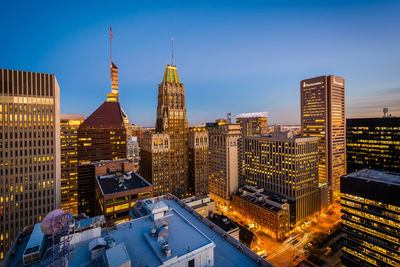 Illuminated buildings in city against sky