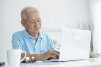 Man using mobile phone while sitting on table