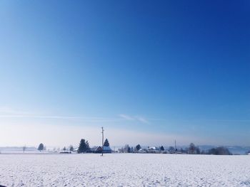 Scenic view of snowy field against clear blue sky