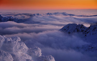 Scenic view of snow covered mountains against sky during sunset