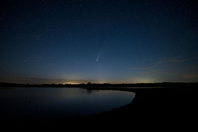 Scenic view of lake against sky at night