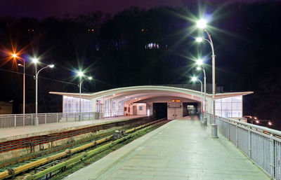 Illuminated railroad station platform at night