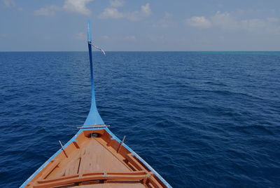 Scenic view of dhoni and sea against sky