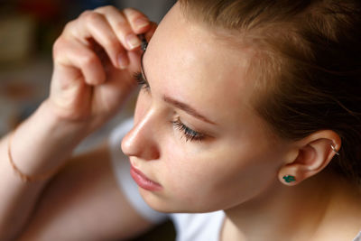 Close-up portrait of young woman with eyes closed