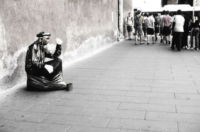 Rear view of woman sitting on floor