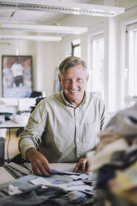 Portrait of smiling male design professional sitting at workshop