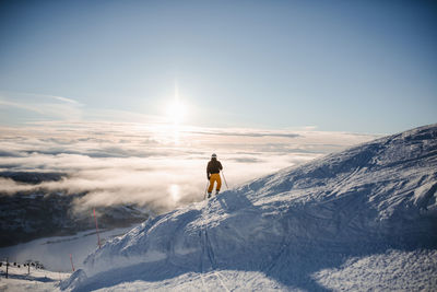 Man on snowcapped mountain against sky