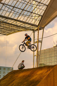 Low angle view of man riding bicycle against sky